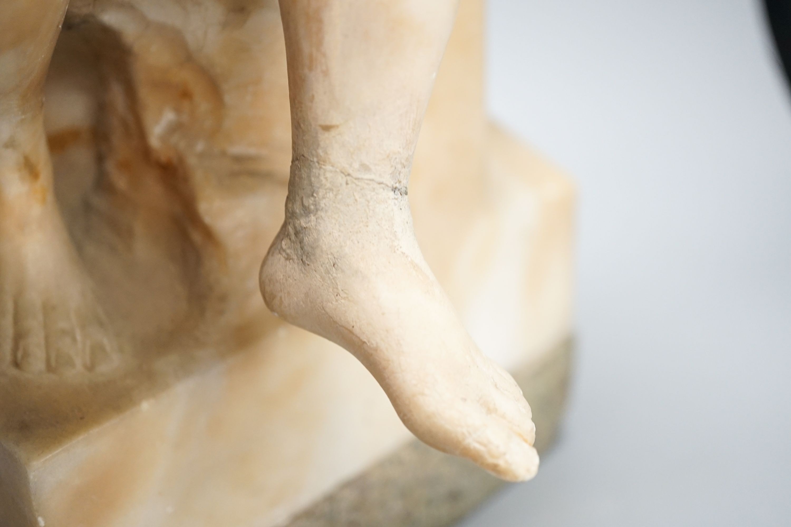 A late 19th century Italian carved alabaster figure of a girl seated, writing at a pillar 47cm